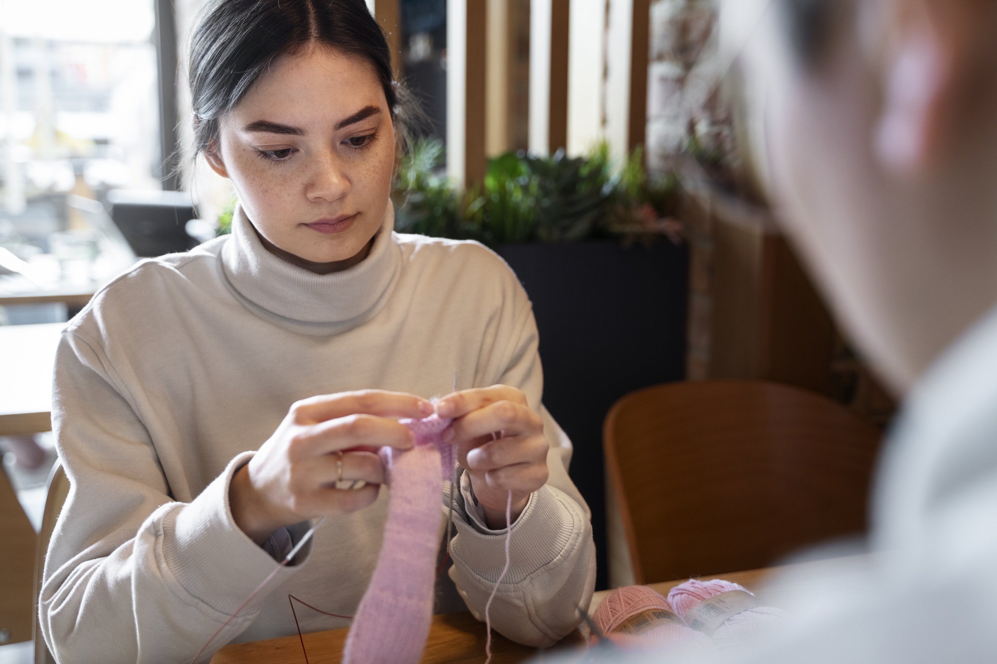 teacher demonstrating satin stitch to a student in studio