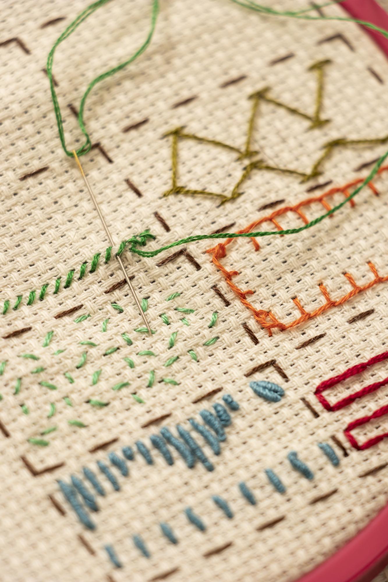 selection of embroidered swatches pinned on board